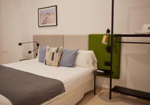 1 dormitorio con 1 cama con cabecero verde y blanco en ISA Cádiz Palacio de Congresos, en Cádiz