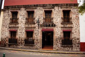 un bâtiment avec une enseigne d'hôtel sur le côté dans l'établissement Hotel el Carmen, Morelia, à Morelia