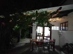 una mesa y sillas frente a una casa por la noche en The Farmhouse B&B en Stellenbosch