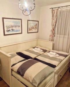 1 dormitorio con 2 camas y lámpara de araña en Bella Garden, en Balatonszárszó