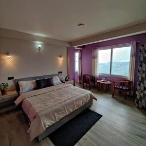 a bedroom with a large bed and a large window at The Silver Spring Homestay in Darjeeling