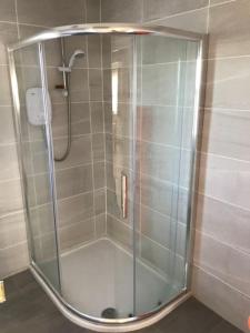 a shower with a glass door in a bathroom at Milo's Cosy Cottage Giant's Causeway in Bushmills