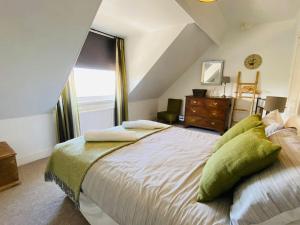 a bedroom with a large bed and a dresser at Chiswell Cottage a large family nr WPNSA & Beach in Castletown