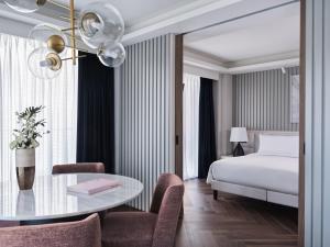 a hotel room with a bed and a table and chairs at Grand Hyatt Athens in Athens