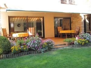 eine Terrasse mit einem Tisch, Stühlen und Blumen in der Unterkunft Haus Anna 