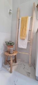 a bathroom with a wooden chair and a towel at Canto da Rocha Guesthouse in Almada