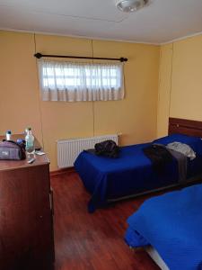 a bedroom with two beds and a window at HOWENH in Porvenir