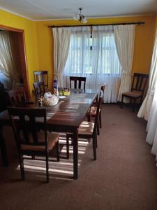 uma sala de jantar com uma mesa de madeira e cadeiras em HOWENH em Porvenir