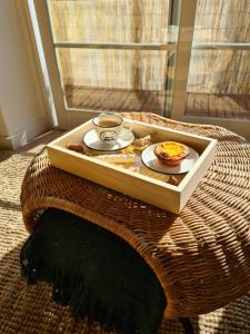 a tray with a cup of coffee and a plate of food at Canto da Rocha Guesthouse in Almada