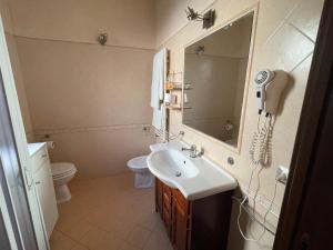 a bathroom with a sink and a mirror and a toilet at AURA l.t in Fiumicino