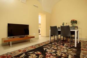 a living room with a table with chairs and a television at CHARMING APARTMENT IN PARMA/ TEATRO REGIO / WIFI in Parma