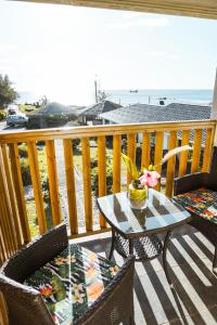 einen Tisch und Stühle auf einem Balkon mit Meerblick in der Unterkunft Matariki Sunset Apart Hotel in Hanga Roa