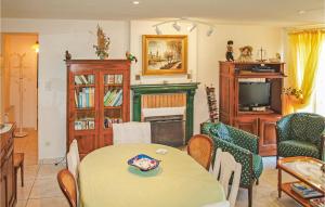 a living room with a table and chairs and a television at 4 Bedroom Lovely Home In Langueux in Langueux