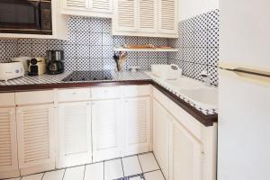 a kitchen with white cabinets and a sink at Viewstar in Gustavia