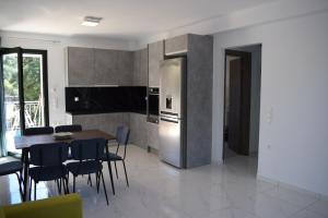 a kitchen with a table and a stainless steel refrigerator at Black & White Apartments in Bekatoráta