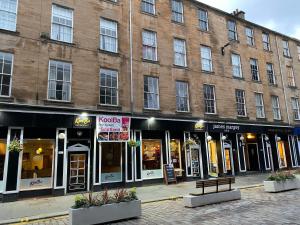 ein großes Backsteingebäude mit einer Bank davor in der Unterkunft Lovely 1-Bed Apartment in Glasgow Merchant City in Glasgow