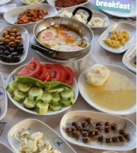 una tavola piena di piatti di prodotti alimentari con pomodori e olive di forest villa-2, 5 minutes from Istanbul airport a Taşoluk