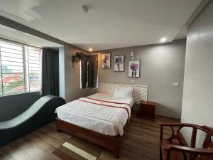 a bedroom with a bed and a window at Hoang Ngan 1 Hotel - TP. Vinh in Vinh