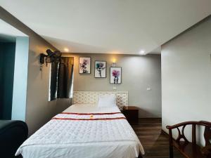 ein Schlafzimmer mit einem großen weißen Bett in einem Zimmer in der Unterkunft Hoang Ngan 1 Hotel - TP. Vinh in Vinh