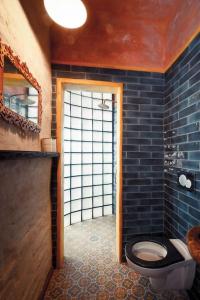 a bathroom with a toilet and a blue tiled wall at Apartmány Za branou in Kutná Hora