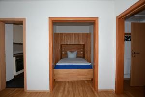 ein kleines Schlafzimmer mit einem Bett in einem Zimmer in der Unterkunft "Gästehaus Flandern" 1 in Borkum