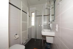 ボルクムにあるGaestehaus-Flandern-1の白いバスルーム(洗面台、トイレ付)