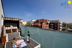 a bottle of wine and a chair on a balcony at Villa Drees Ferienwohnung 12 in Wangerooge