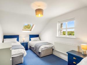 a bedroom with two beds and a window at Sycamore Cottage in Clifden
