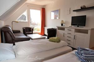 Haus-Koenigsduene-I-4 في بوركوم: غرفة بسرير وتلفزيون وأريكة