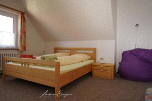 a bedroom with a bed and a purple pillow and a window at Haus-Koenigsduene-I-4 in Borkum
