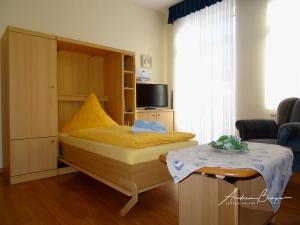 ボルクムにあるHaus-Moana-Wohnung-1のベッドルーム1室(ベッド1台、小さなテーブル付)