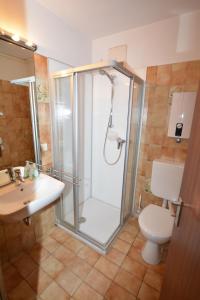 a bathroom with a shower and a toilet and a sink at Nordseehus-Whg-2 in Borkum