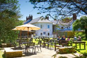 a group of people sitting at tables in front of a house at The Grove in St. Davids