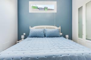1 dormitorio azul con 1 cama con paredes azules en Home2Book El Perenquén San Nicolás 1 en Las Palmas de Gran Canaria