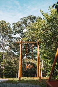 a swing in a park with trees in the background at Nomads Flats in Itacaré