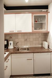 a kitchen with white cabinets and a sink at Ferienwohnung & App. Rosemarie in Bad Birnbach