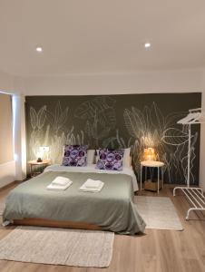 1 dormitorio con 1 cama grande con almohadas moradas en Enallio Luxury Apartments, en Nauplia