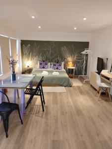 1 dormitorio con 1 cama, mesa y sillas en Enallio Luxury Apartments, en Nauplia