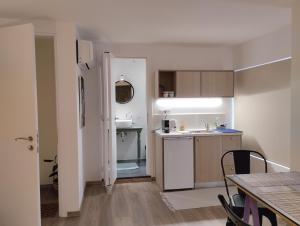 a small kitchen with a sink and a table at Enallio Luxury Apartments in Nafplio