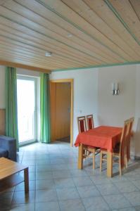 uma sala de jantar com uma mesa vermelha e cadeiras em Ferienwohnung & App. Rosemarie em Bad Birnbach