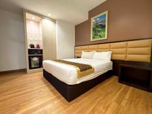 a bedroom with a large bed and a fireplace at Hallmark Crown Hotel in Melaka