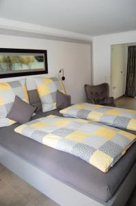 um quarto com uma cama grande com almofadas amarelas e cinzentas em Ferienwohnung & App. Rosemarie em Bad Birnbach