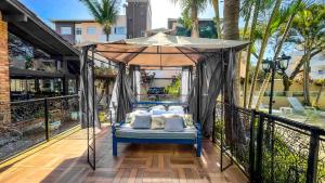 a bed in a canopy on a balcony with palm trees at Hotel & Pousada Sonho Meu in Florianópolis