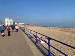 a group of people walking along the beach at The Mowbray in Eastbourne