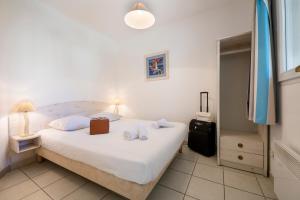 a bedroom with a large white bed and a suitcase at Garden & City Six-Fours-les-Plages in Six-Fours-les-Plages