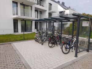 um grupo de bicicletas estacionadas sob um dossel em frente a um edifício em Villa Neptun Gdańsk 5 1 9 1 0 2 1 3 0 em Gdańsk