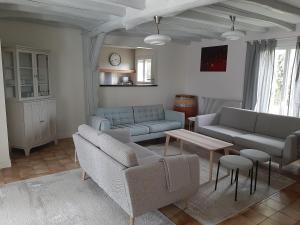 een woonkamer met 2 banken en een tafel bij Maison Bleue in Montagne