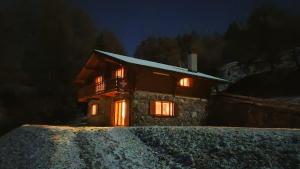 ein Haus mit nachts eingeschaltetem Licht in der Unterkunft Belle Vie sur les pistes in Veysonnaz