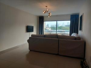a living room with a couch and a large window at Umhlanga Beach 3 Bedroom Apartment in Durban