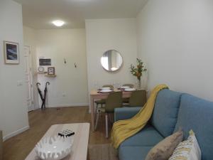 salon z niebieską kanapą i stołem w obiekcie Marea Urban w mieście La Laguna +10 zdjęć